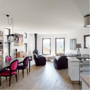 Vue intégrale d'une maison moderne et design, comprenant salle à manger, salon et cuisine, mise en valeur par Capture Immo.