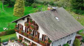 Photos aériennes capturées par drone d'une maison traditionnelle en pierre en Suisse.